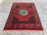 Unique hand-knotted Turkmen rug with rich red background, intricate geometric patterns, and a central green medallion, measuring 5.4 feet by 6.9 feet.