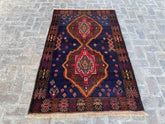 Afghan vintage tribal rug with bold medallion design, featuring rich reds, vibrant blues, and earthy tones, measuring 4'0" x 6'6