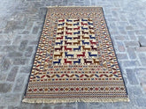 "Handwoven Afghan Soumak Kilim rug with a beige background, colorful animal motifs, and geometric borders, measuring 4'1" x 6'10"