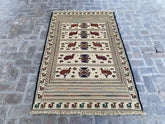 "Handwoven Afghan Soumak Kilim rug with a beige background, animal patterns, and geometric motifs, measuring 4'3" x 6'6"