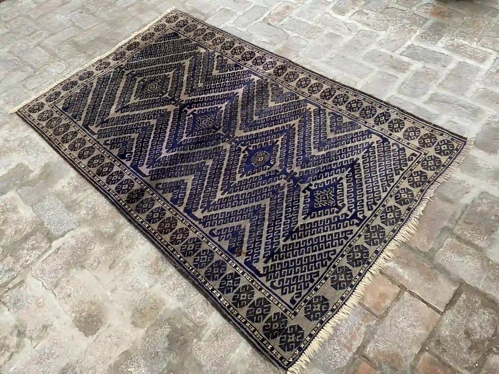 Afghan handmade rug with geometric patterns in blue, beige, and black, 3.8 x 6.0 feet.