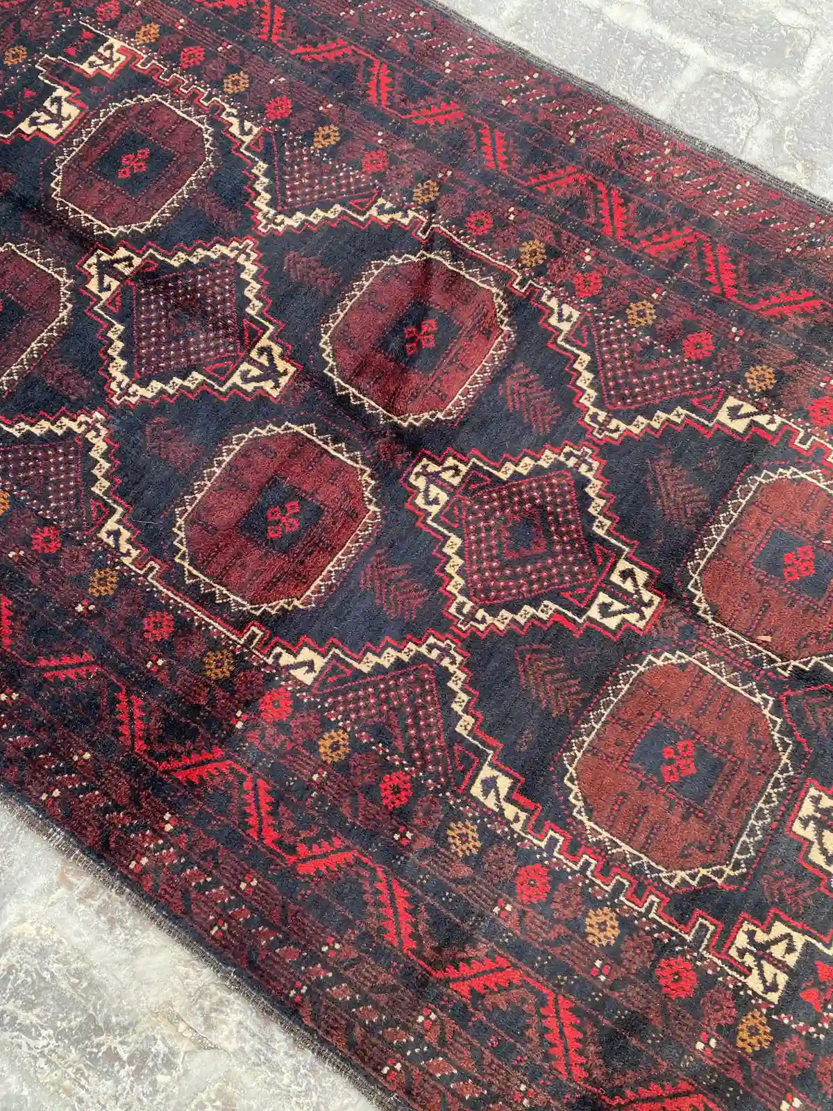 Beautiful hand-knotted Belouch rug in rich red and navy with abundant diamond patterns, measuring 3.8 feet by 7 feet.