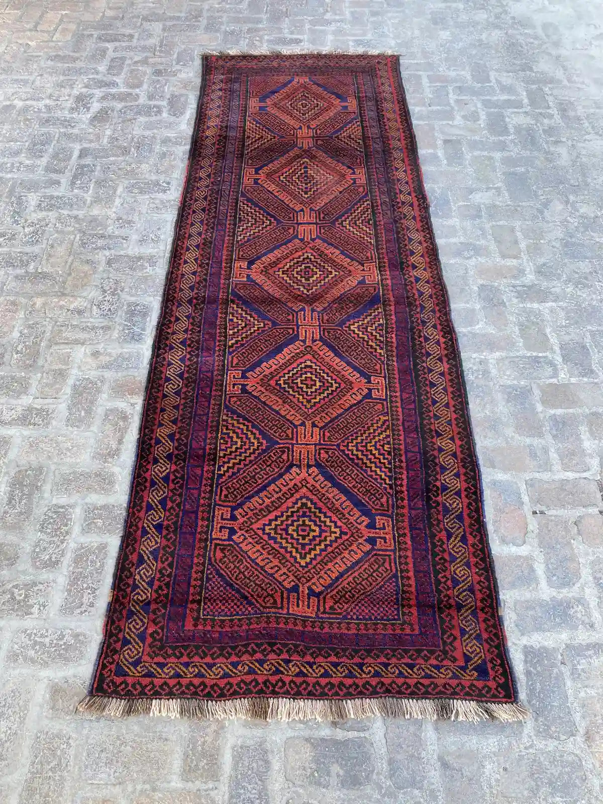 "Hand-knotted Afghan Belouchi rug runner with geometric diamond patterns in red and blue, measuring 4'0" x 11'10", vintage from 2000.