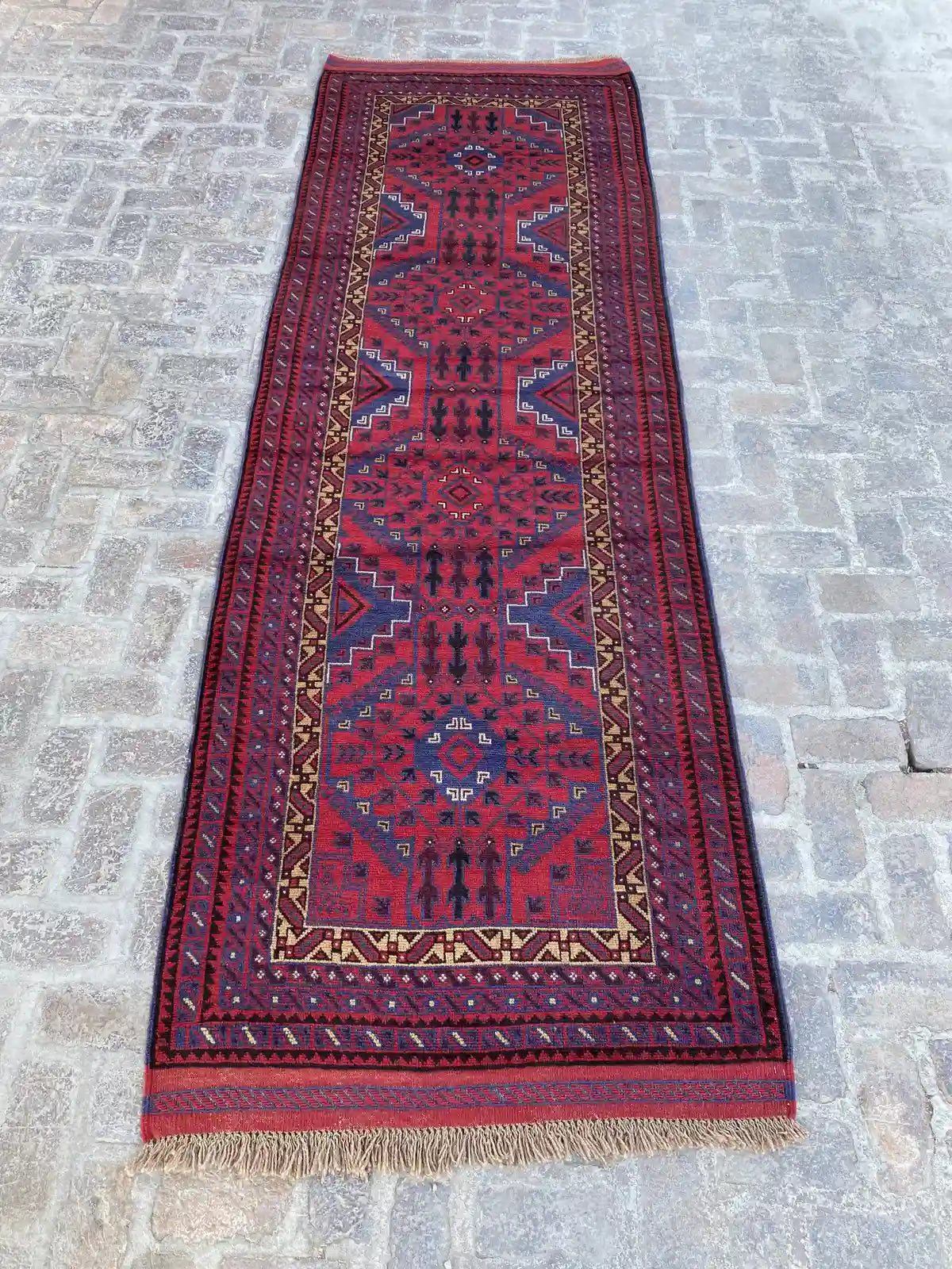 Hand-knotted Afghan Belouchi rug runner with vibrant red background, blue and yellow geometric tribal patterns, measuring 4'0" x 12'3