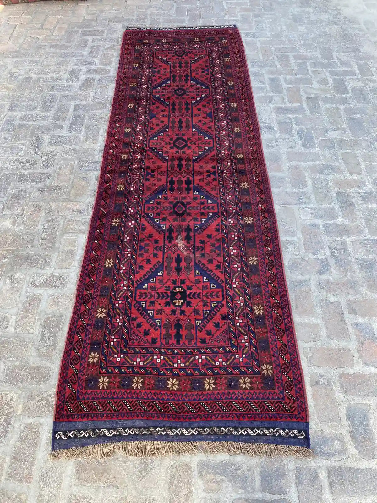 "Handmade Afghan Mishwani runner with a red background and blue geometric patterns, measuring 3'11" x 12'6"