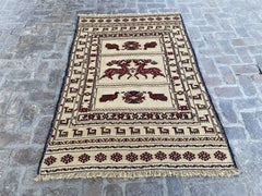 "Handwoven Afghan Soumak Kilim rug with a beige background, brown animal patterns, and geometric motifs, measuring 4'3" x 6'3"